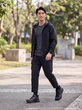 Biom 720 Goretex – A pair of charcoal grey ripstop cargo pants paired with a moisture-wicking olive green base layer and a black technical hardshell jacket for a complete trail-ready look.