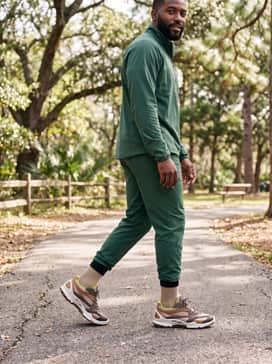 Biom Ctrail – Grey performance leggings under navy running shorts, paired with a forest green half-zip trail pullover for high-intensity outdoor training.
