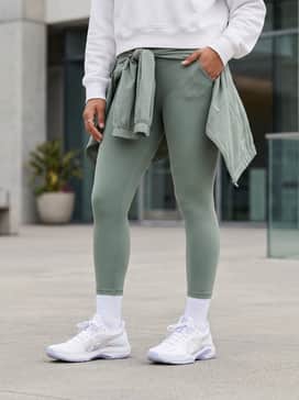 High-waisted sage green leggings and a cropped white hoodie for a fresh, balanced gym-to-brunch ensemble.