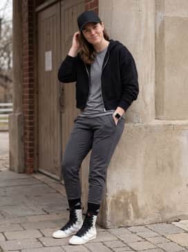 Box Hog 4 Shoes – A sleek athleisure outfit consisting of charcoal grey compression leggings, a black cropped zip-up hoodie, and a minimalist baseball cap for a focused gym-to-street vibe.