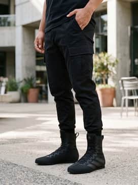 A sleek urban techwear outfit with black tapered cargo pants, a white oversized long-sleeve tee, and a tactical utility vest in matte black.