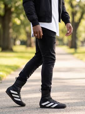 Box Hog 4 Shoes – A bold streetwear style using black skinny distressed denim tucked into the boots, a longline white t-shirt, and a vintage-style nylon bomber jacket.