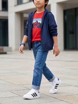Classic blue straight-leg jeans paired with a bright graphic t-shirt and a lightweight navy windbreaker for a timeless look.