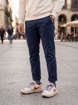 Navy blue slim-fit chinos and a cream-colored heavyweight cotton sweatshirt for a clean, smart-casual aesthetic that transitions from the office to the street.