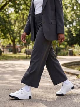 Tailored charcoal wide-leg trousers with a crisp white baby tee and an unbuttoned oversized blazer for a sophisticated smart-casual office aesthetic.