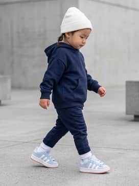 Navy blue joggers paired with a matching graphic hoodie and a small white beanie for a coordinated athletic look.