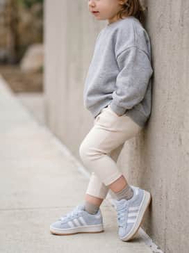 Cream-colored ribbed leggings and an oversized heather grey sweatshirt for a cozy, neutral-toned outfit that lets the blue shoes pop.