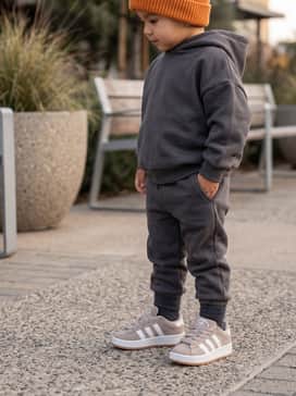 Charcoal grey fleece joggers combined with a matching oversized hoodie and a bright knit beanie to add a pop of color against the neutral shoe palette.