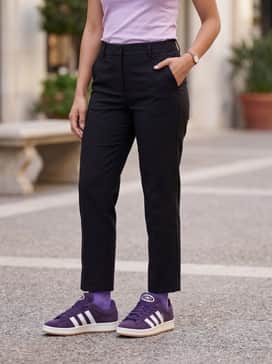 Straight-leg black trousers and a tucked-in lilac baby tee for a coordinated tonal purple outfit.