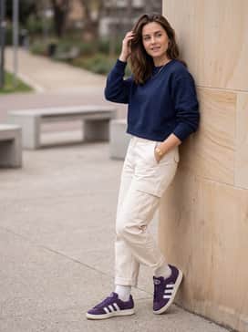 Relaxed-fit cream cargo pants with a cropped navy blue sweatshirt for a clean, contrasting streetwear look.