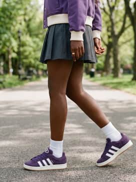 A charcoal grey pleated mini skirt with white crew socks and a matching purple varsity jacket for a sporty-preppy vibe.