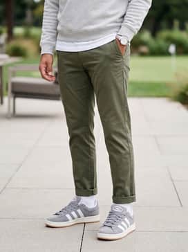 Classic olive green chinos cuffed at the ankle, a white heavyweight cotton t-shirt, and a light grey quarter-zip pullover for a versatile weekend outfit.