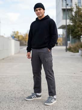 Charcoal grey cargo pants and an oversized black hoodie with a neutral beanie for a modern, edgy streetwear aesthetic.