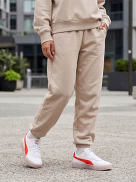 A neutral beige oversized sweat suit for a monochrome lounge look that lets the vibrant orange stripes and translucent sole act as the focal point.