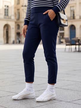 Casual Luxe: Slim-fit navy joggers paired with a crisp white crewneck sweatshirt and a structured gold-buckle belt bag to match the shoe's accents.