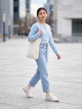 Charge Canvas – High-waisted light wash straight-leg jeans paired with a tucked-in baby blue cropped cardigan and a cream-colored tote bag.