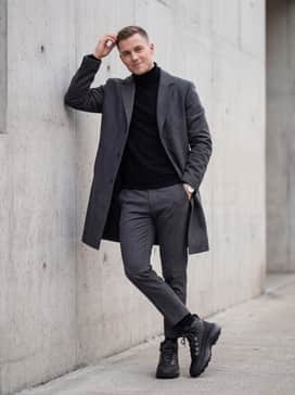 City – An elevated urban outfit comprising charcoal grey chinos, a black merino wool turtleneck sweater, and a long-cut wool overcoat to balance the boot's ruggedness with sophisticated lines.