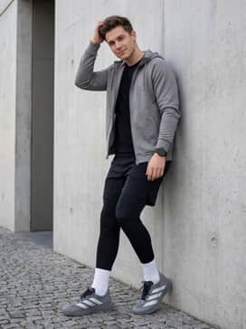 An athletic aesthetic pairing black performance leggings or shorts with a matching grey zip-up hoodie and high-performance white crew socks.