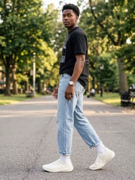 A modern street style look using relaxed-fit light-wash cropped denim, a bold graphic streetwear tee, and white crew socks to emphasize the shoe's unique lattice texture.