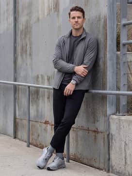 Tapered black technical joggers, a moisture-wicking base layer, and a matching grey windbreaker for a cohesive outdoor training outfit.