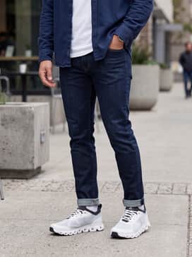 Dark-wash slim-fit denim paired with a premium white t-shirt and an unbuttoned navy flannel shirt for a relaxed yet put-together weekend look.