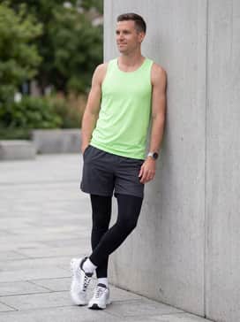 Performance-ready 7-inch running shorts in charcoal with a moisture-wicking neon green tank top for high visibility and comfort during workouts.