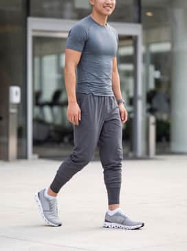 Cloud X 4 – A pair of charcoal performance leggings worn under black moisture-wicking shorts, a fitted slate grey compression shirt, and no-show athletic socks for a focused gym session.