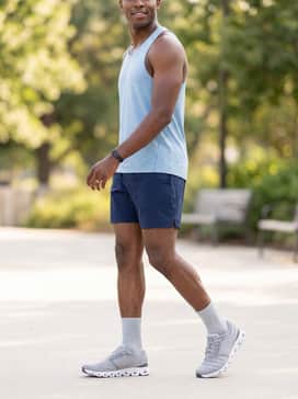 Cloud X 4 – Mid-thigh length navy blue performance shorts, a breathable light blue racerback singlet, and a sleek fitness tracker for a clean, high-performance summer workout outfit.