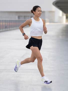 Cloudboom Strike – A sleek racing-day look featuring ultra-lightweight black split shorts, a moisture-wicking white mesh crop tank, and technical no-show socks.