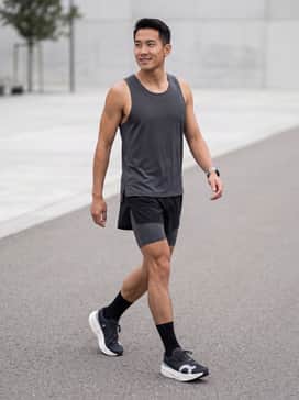A race-day kit featuring ultra-lightweight split running shorts in matte black and a laser-cut perforated singlet in a matching dark grey.
