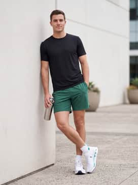 Matching teal or forest green athletic shorts paired with a minimalist black tech-tee to highlight the shoe's distinct midsole color pop.