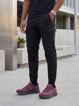 Cloudflow 5 Ad – A casual streetwear ensemble consisting of black tapered tech-cargo pants, a cream-colored oversized hoodie, and a burgundy baseball cap that mirrors the shoe's color.