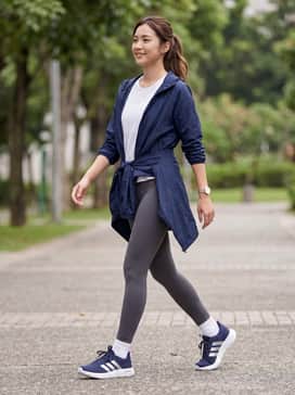 High-waisted charcoal leggings paired with a breathable white mesh tank and a lightweight navy blue windbreaker for a sleek gym-to-street look.