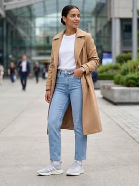 Light-wash cropped straight-leg jeans with a tucked-in white crewneck t-shirt and a camel-colored trench coat for a polished yet comfortable weekend outfit.