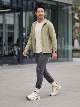 A performance-ready look featuring black compression tights under olive green micro-mesh running shorts paired with a moisture-wicking cream technical tee.