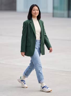 Cloudnova Moon – A pair of light-wash straight-leg denim jeans cuffed at the ankle, worn with a tucked-in cream mock-neck top and an oversized forest green blazer.