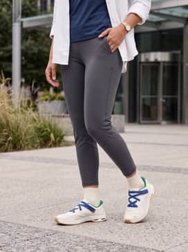 High-performance navy blue leggings paired with a matching crop top and an unbuttoned white linen shirt for a sophisticated post-gym look.