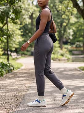Cloudnova Moon – Tapered charcoal joggers with a fitted black bodysuit and a crossbody bag for a sleek and functional streetwear ensemble.