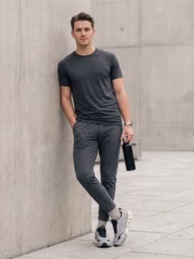 An urban techwear outfit using slim-fit olive cargo pants, a black oversized graphic t-shirt, and a technical utility vest to highlight the shoe's architectural sole.