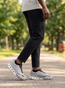 A summer training outfit featuring 7-inch charcoal running shorts, a sleeveless black performance hoodie, and low-profile no-show socks for a streamlined silhouette.
