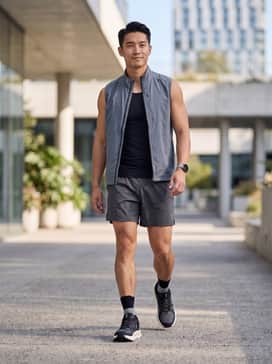 A high-performance running outfit featuring charcoal grey moisture-wicking shorts, a black compression tank, and reflective ankle socks for safety.