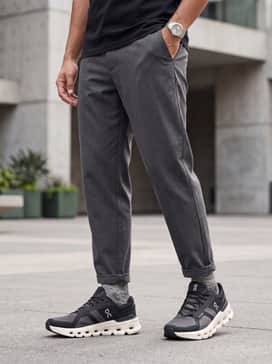 A sharp athleisure look pairing tapered black joggers with a crisp white tech-fabric tee and a lightweight olive green bomber jacket.