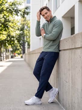 Cloudrunner 3 – A functional urban look pairing navy blue water-resistant cargo track pants with a breathable quarter-zip pullover in a muted sage green, perfect for an active commute.