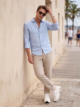 Cloudsolo Loewe – Beige linen trousers, a light blue button-down shirt left untucked, and a pair of designer sunglasses for a sophisticated coastal-casual vibe.