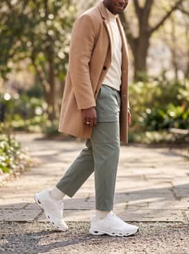 Cloudsolo Loewe – Sage green cargo pants, a cream mock-neck sweater, and a camel-colored overcoat for a layered, high-low fashion statement.