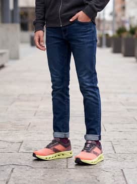 Slim-fit dark wash denim jeans paired with a crisp white graphic tee and a charcoal zip-up hoodie for a cool school-day outfit.