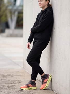 Tapered black joggers and a matching tech-fleece sweatshirt to create a monochromatic base that makes the bright lime green soles pop.