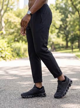 A modern summer sport outfit pairing black athletic-fit mesh shorts with a breathable sage green tank top, finished with high-performance no-show socks and a black baseball cap.