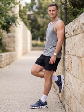 A summer-ready athletic outfit with 7-inch black performance shorts, a heather grey racerback tank top, and low-profile white athletic socks to emphasize the shoe's silhouette.
