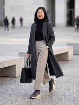 Cloudtilt Loewe – High-waisted wide-leg trousers in a neutral stone shade paired with a fitted black turtleneck and a long charcoal wool overcoat for a sophisticated city look.